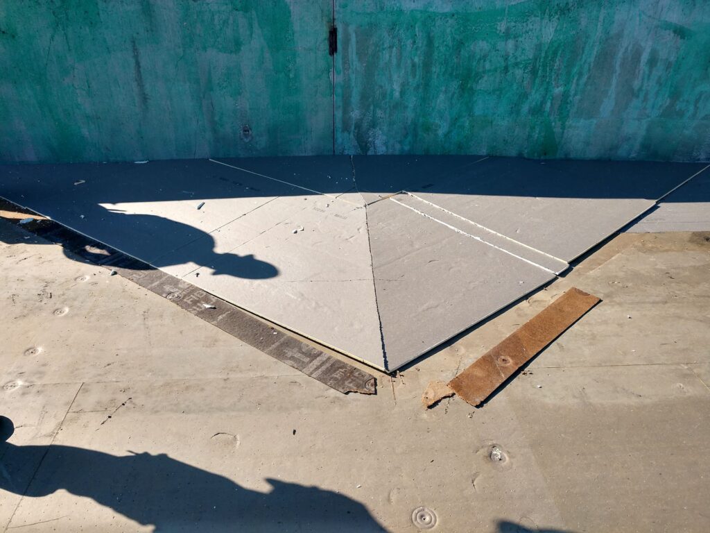 Industrial roof cricket with coverboard over the top
