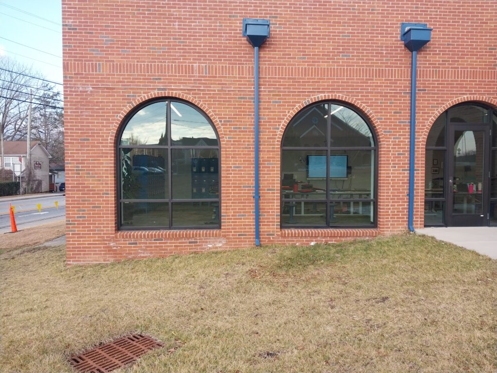 Rain collector heads and downspouts on a school roof