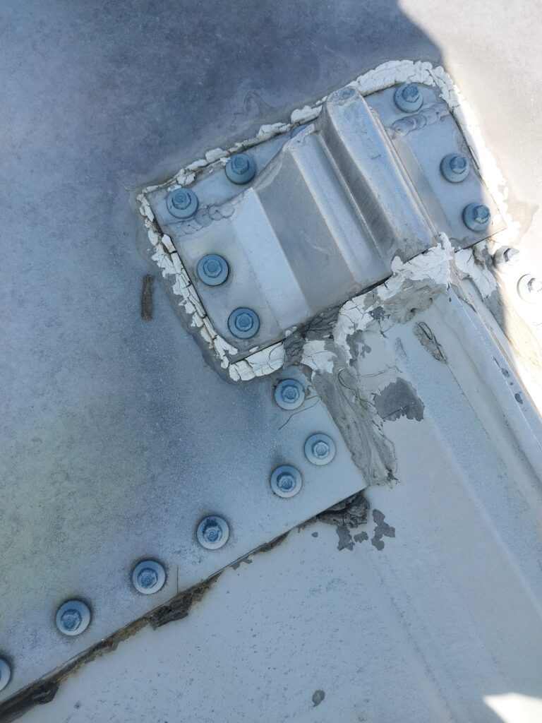 Deteriorating metal roof sealant found during a roof inspection