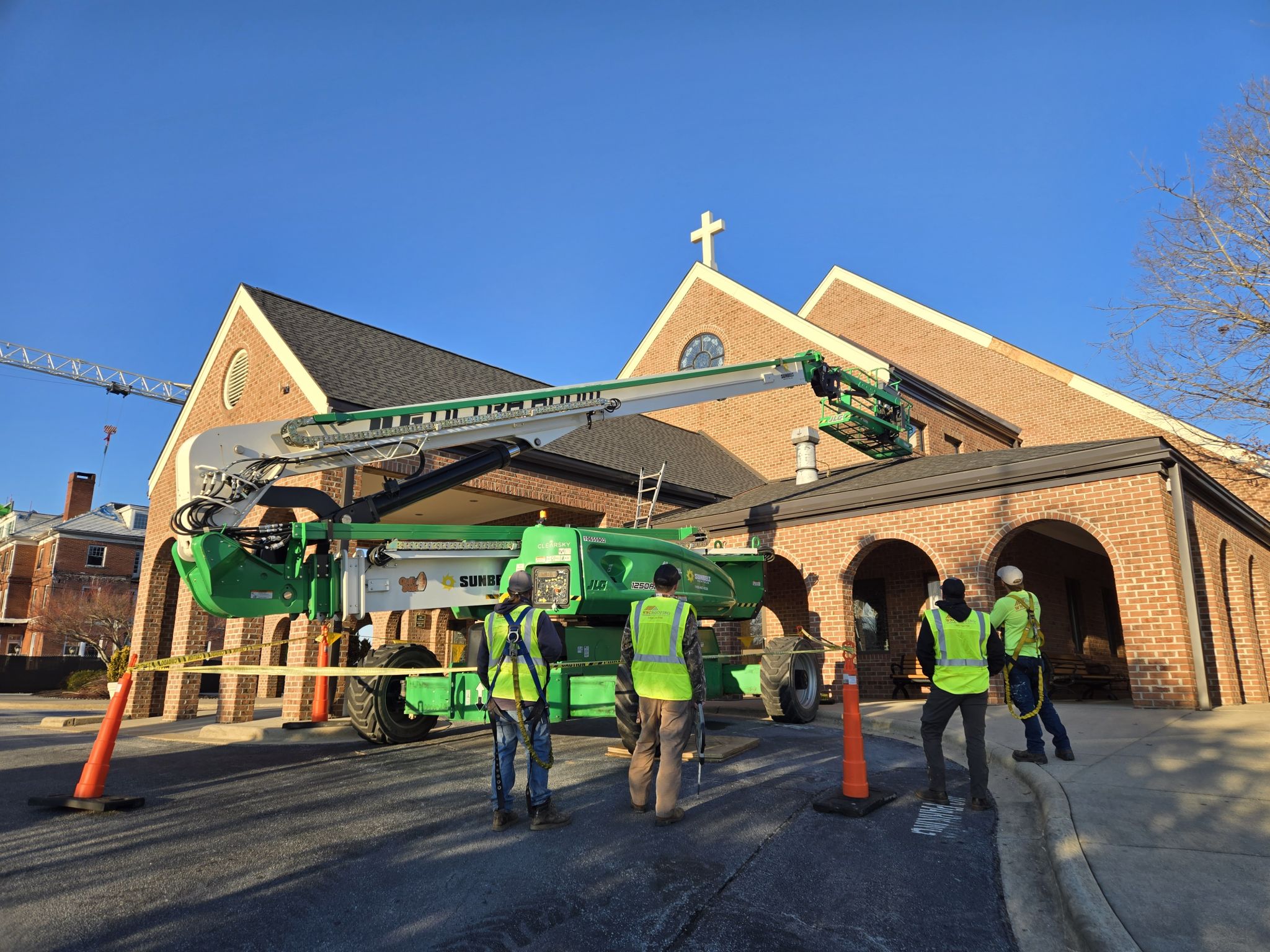 Wnc roofing crew and lift replacing metal detail at a church