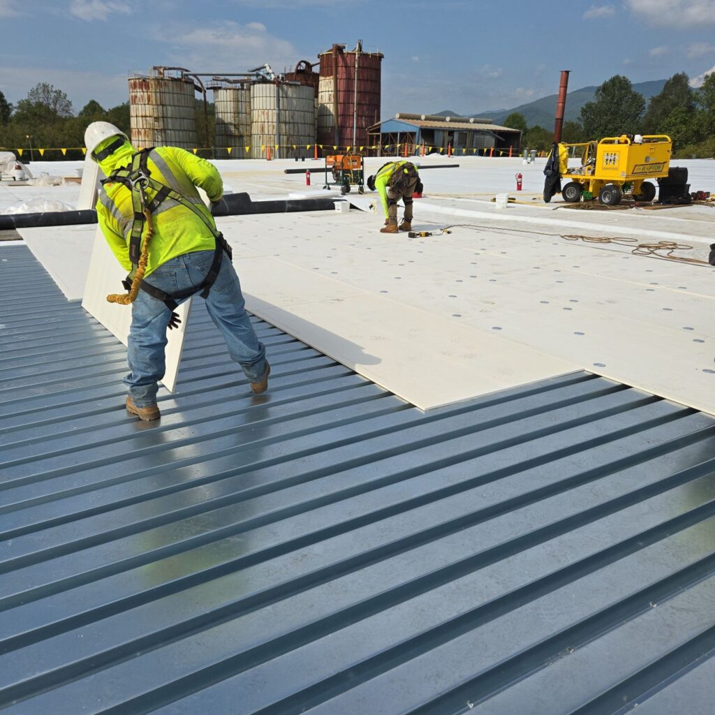 Laying down and attaching new roof insulation.