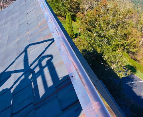 New rustic metal roof cap on slate roof